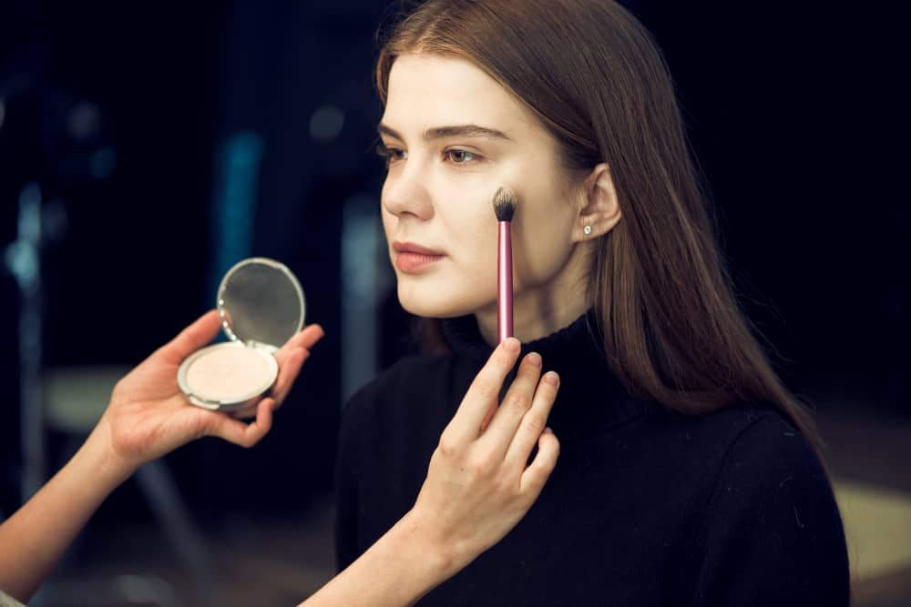 woman applying primer before foundation makeup